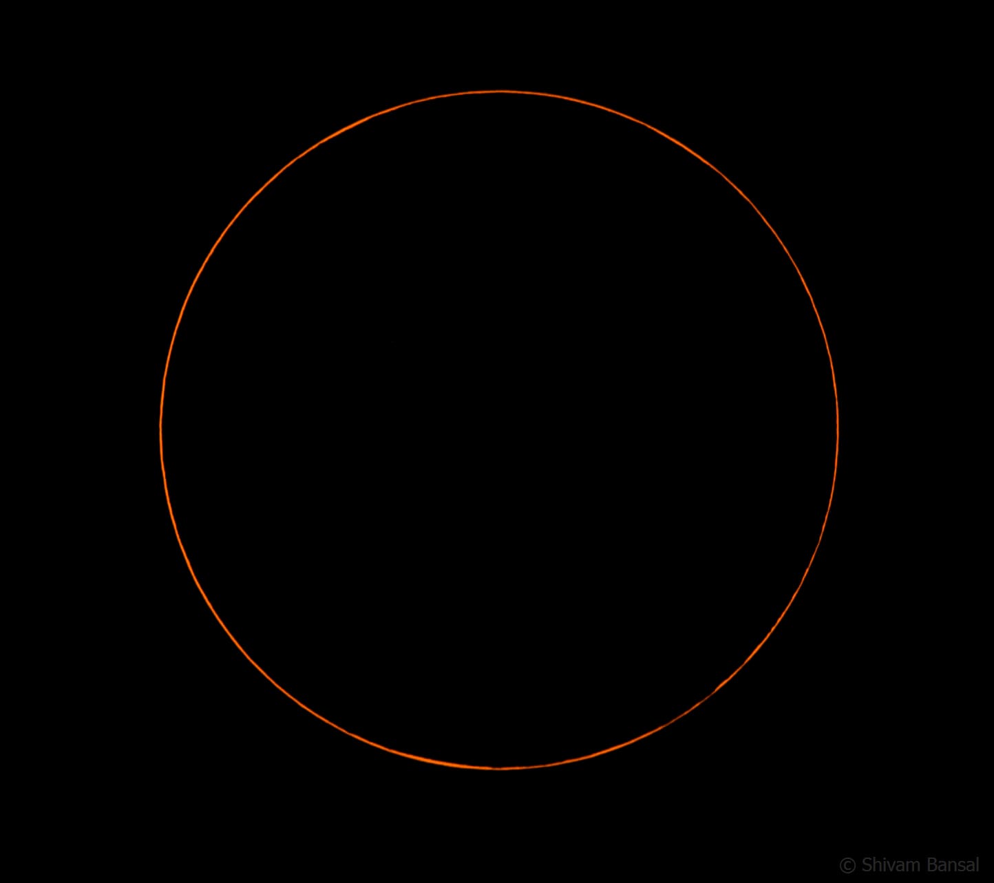 A thin, perfectly even orange ring of light on a black background, formed by the Moon centered in front of the Sun.