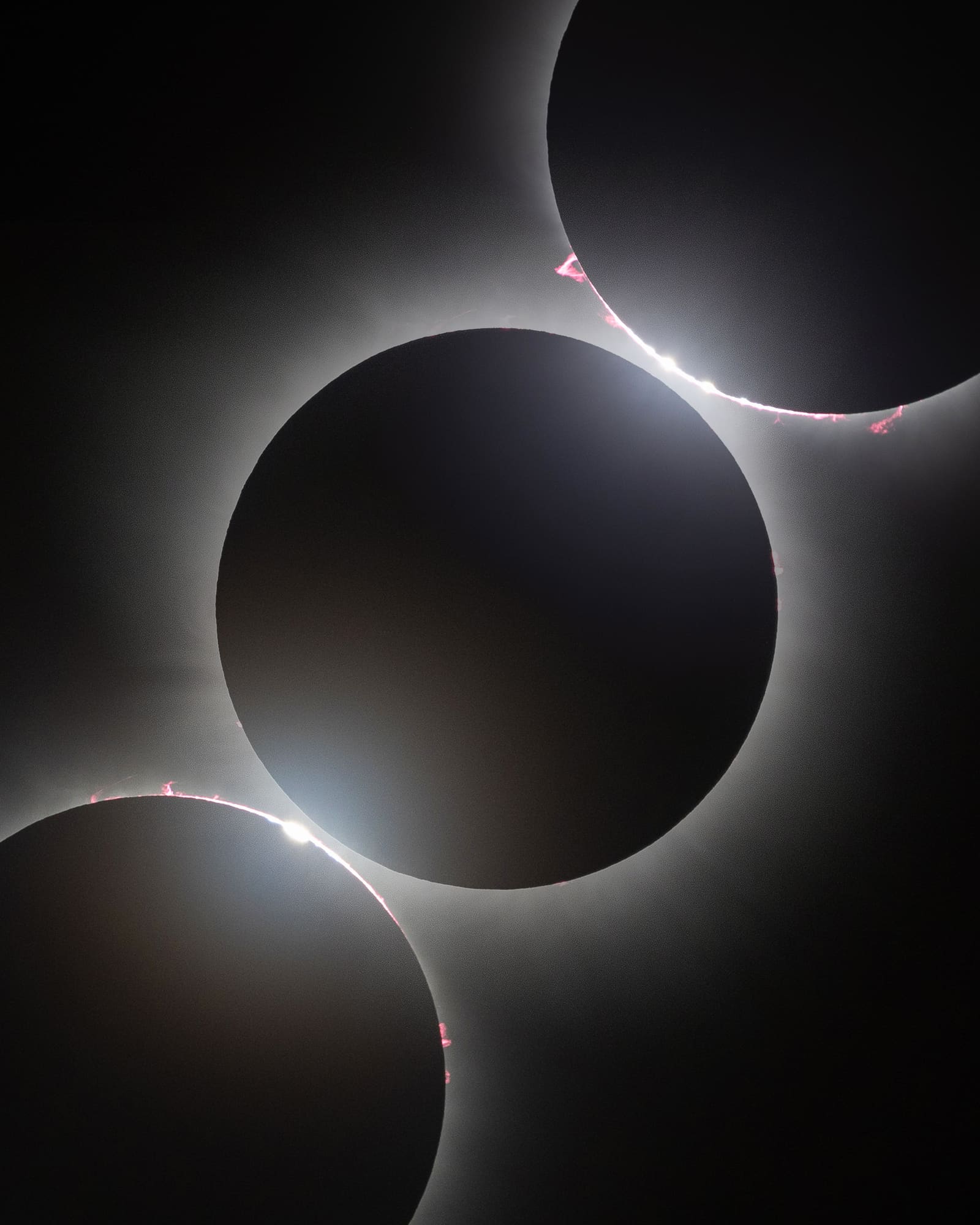 A curved arrangement of partially eclipsed sun images surrounding a central black disc totality image with visible corona.