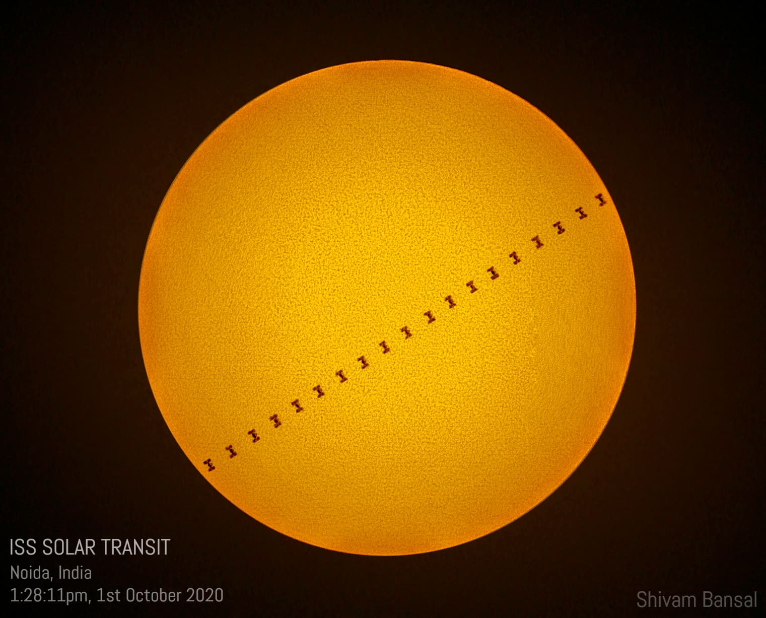 Orange solar disc with a diagonal line of small dark silhouette marks showing the ISS's transit path, captioned with location and time.