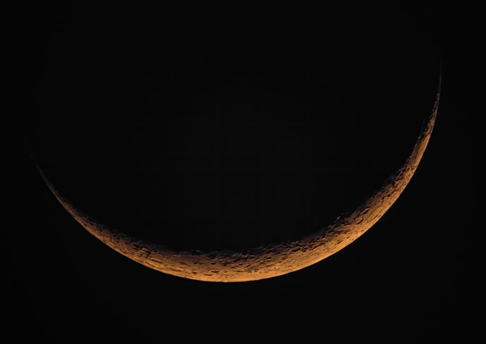 A detailed full moon with warm tan tones and visible bright ray systems radiating from craters.