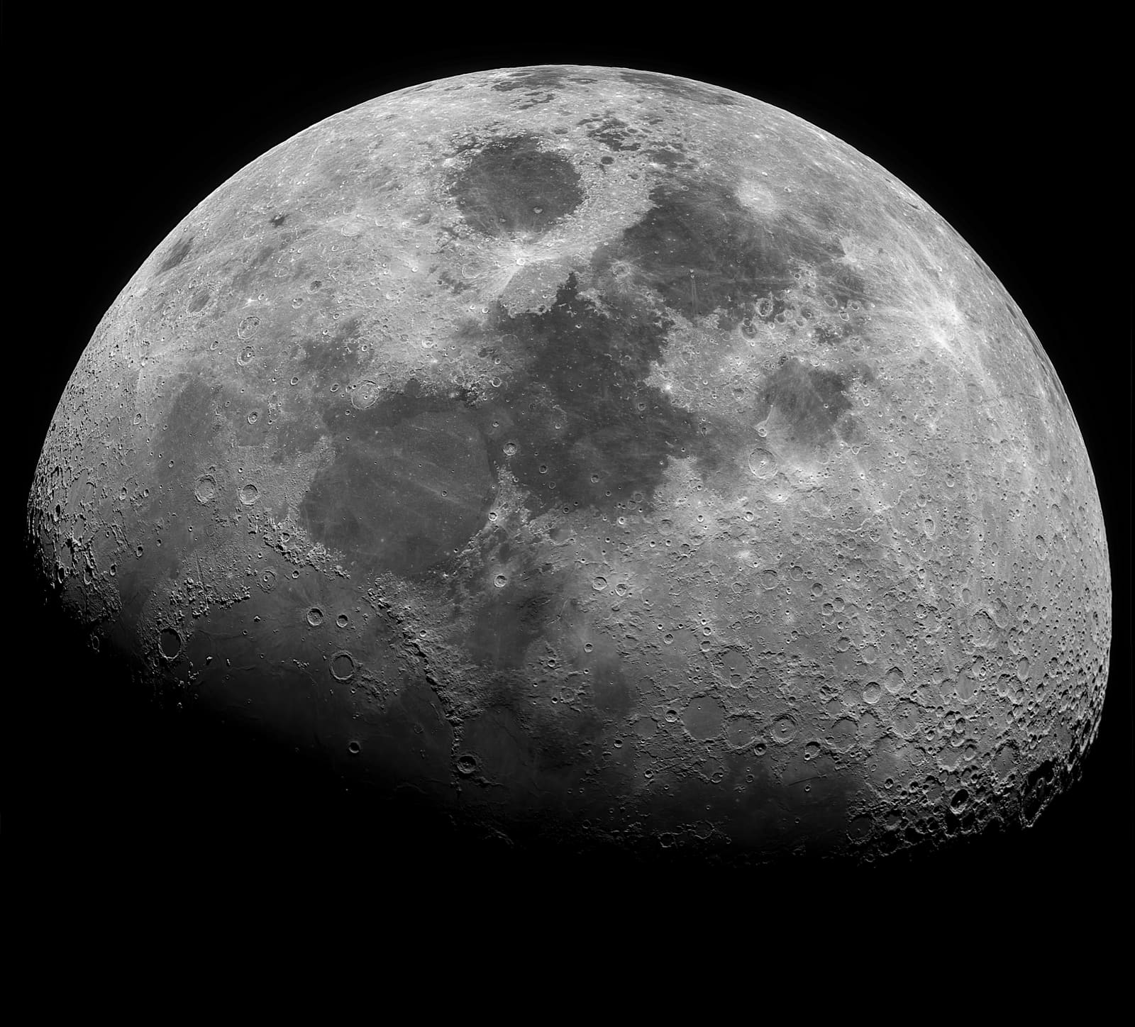 A detailed grayscale gibbous moon with a curved terminator, craters near the shadow line standing out in high relief.
