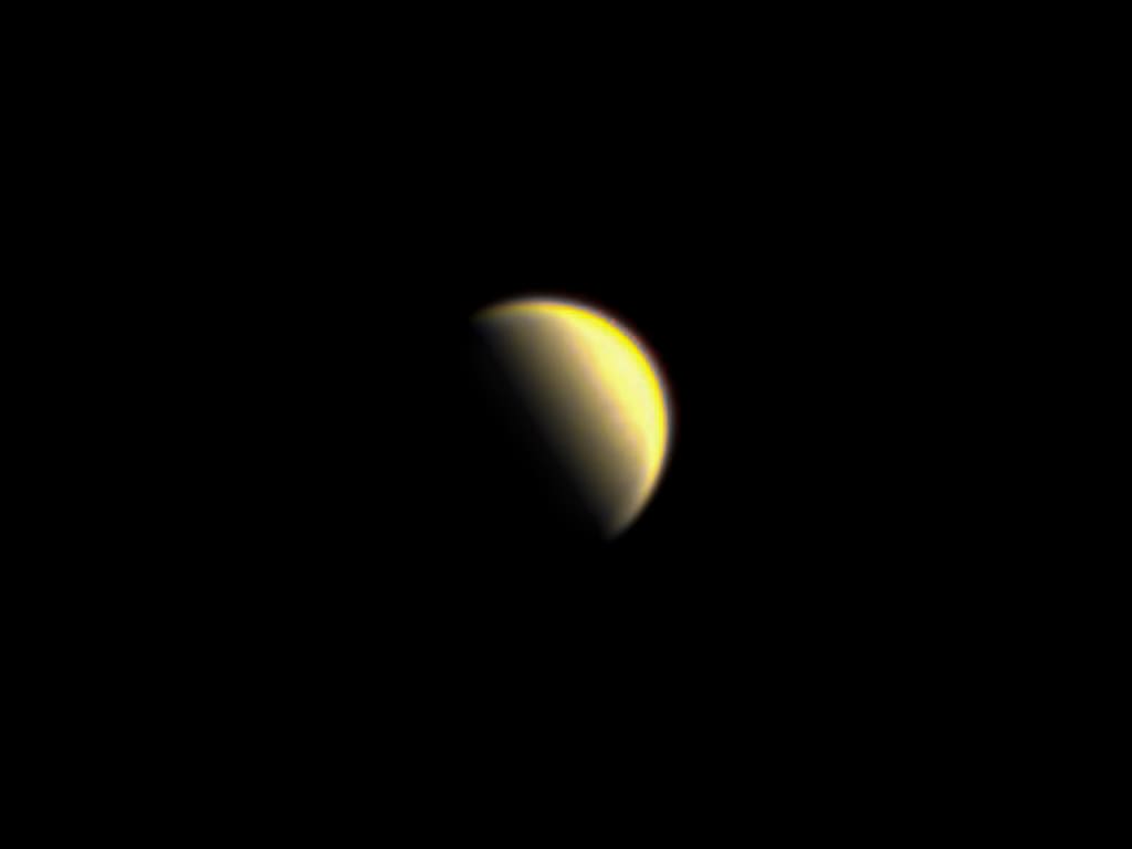 Telescopic image of Venus as a bright yellow-white crescent against black space, most of its disc in darkness.