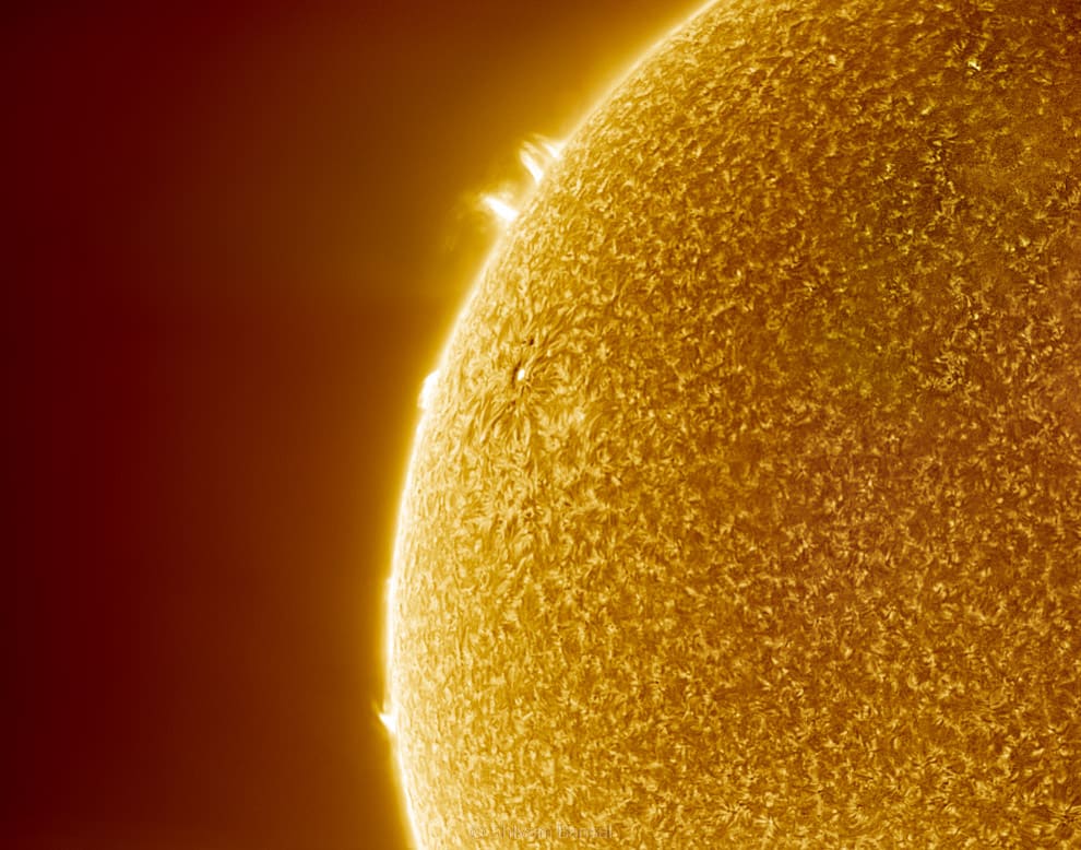 HDR close-up of the sun's limb showing fine bright spicules and small jets rising off the granulated chromosphere edge against dark space.